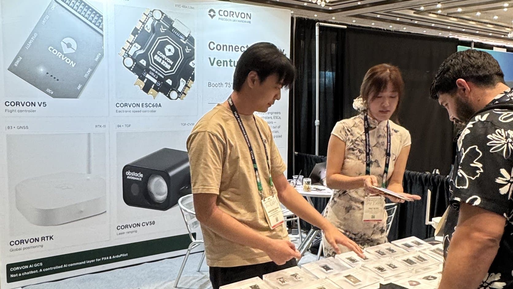 CORVON team walking a visitor through products at the Commercial UAV Expo 2026 booth